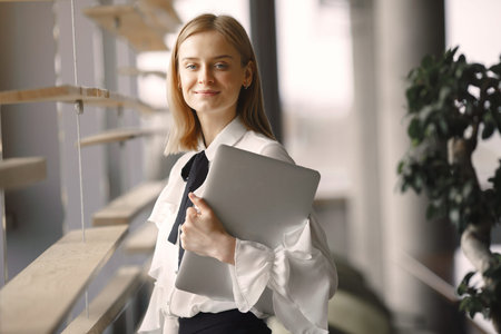 Businesswoman standing in the office with a laptop