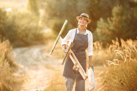 Woman in a apron painting in a fieldの写真素材