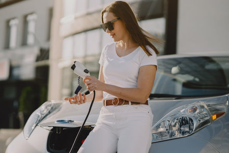 Woman charging electro car at the electric gas stationの写真素材