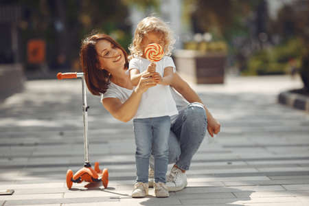 Mother with daughter in a spring park with skateの写真素材