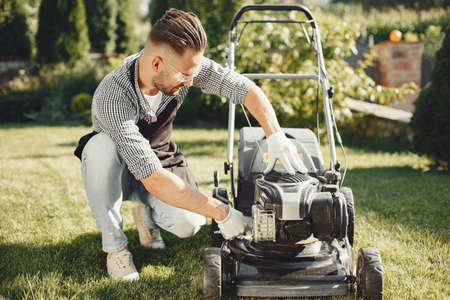 Man repairs lawnmover in a backyardの写真素材