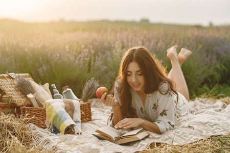 Woman in a lavender field sitting on a blanketの写真素材