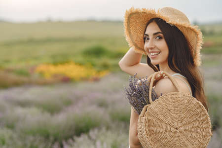 Young woman collects lavender in a basketの写真素材