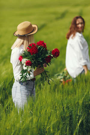 Women in elegant clothes standing in a summer fieldの写真素材