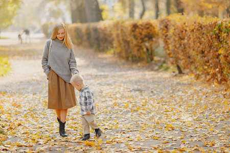Mother with little son playing in a autumn fieldの写真素材