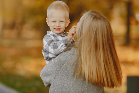 Mother with little son playing in a autumn field
