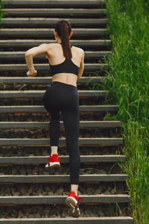 Woman in a black spoerswear standing on a stairsの写真素材