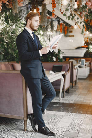 Man standing at the office with documentsの写真素材