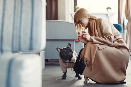Elegant woman in a brown coat with black bulldogの写真素材