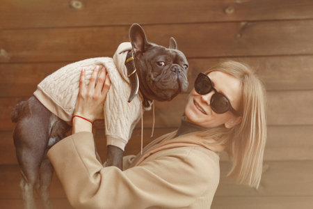 Elegant woman in a brown coat with black bulldogの写真素材