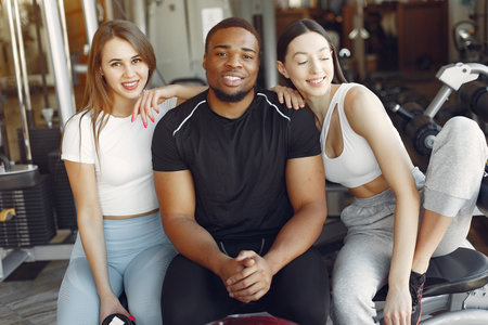 Young sports people sitting in a morning gymの写真素材