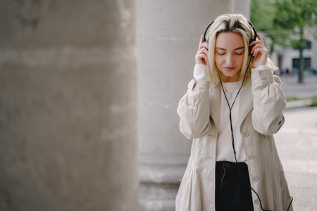 Blonde listen music in a summer cityの写真素材