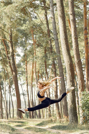 Cute girl doing yoga in a summer forestの写真素材