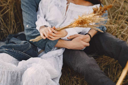 Happy couple in love in wheat field at sunsetの写真素材