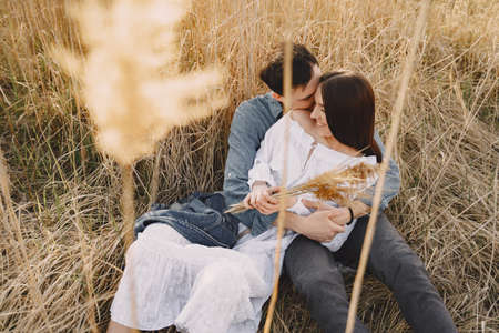 Happy couple in love in wheat field at sunsetの写真素材