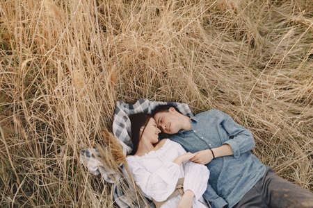 Happy couple in love in wheat field at sunsetの写真素材