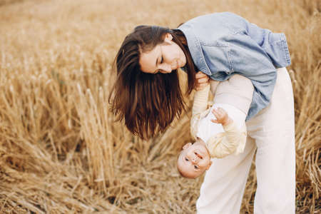 Mother with daughter playing in a autumn fieldの写真素材