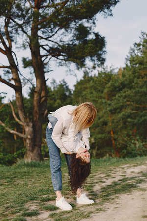 Elegant mother with daughter in a summer forestの写真素材