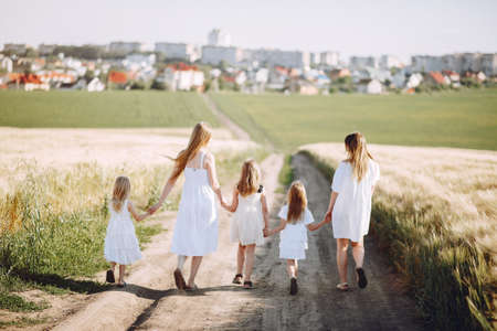 Mothers with daughters playing in a autumn fieldの写真素材