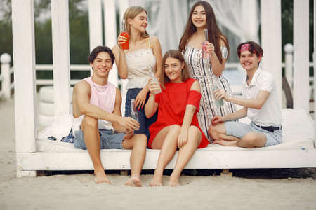 Friends have fun on a beach with drinksの写真素材