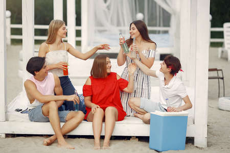 Friends have fun on a beach with drinksの写真素材