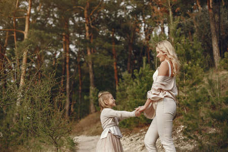 Elegant mother with daughter in a summer forestの写真素材
