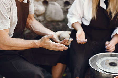 People making a vaze from a clay on a potterys machineの写真素材