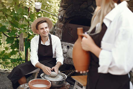 People making a vaze from a clay on a potterys machineの写真素材
