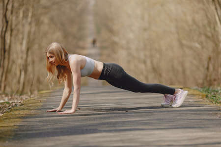 Sports girl training in a summer forestの写真素材