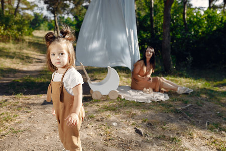 Mother with little daughter playing in a summer fieldの写真素材