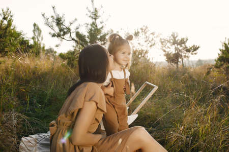 Mother with little daughter playing in a summer fieldの写真素材