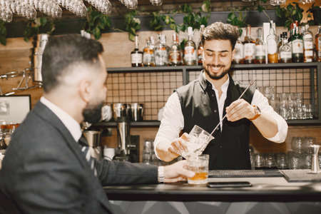 Handsome bartender talking with a customerの写真素材