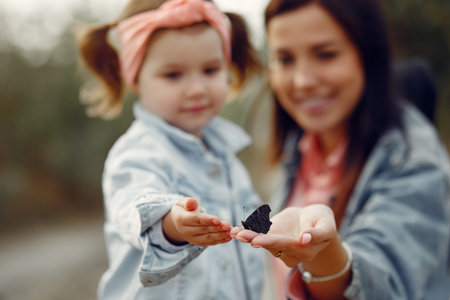 Mother with little daughter playing in a autumn field