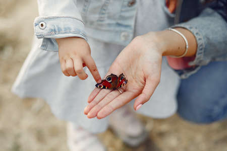 Mother with little daughter playing in a autumn fieldの写真素材