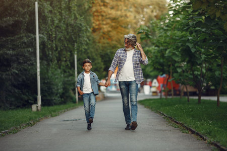 Grandfather with grandchild walking in a summer park
