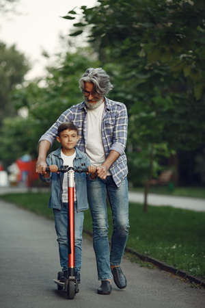 Grandfather with grandchild walking in a summer parkの写真素材