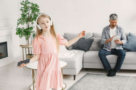 Little girl listening music in headphones with grandfatherの写真素材