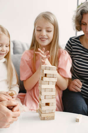Grandparents play tower game with two girlsの写真素材