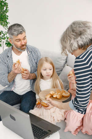 Grandmother treating husband and two girls with cookiesの写真素材