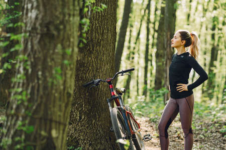 Woman riding a mountain bike in the forestの写真素材