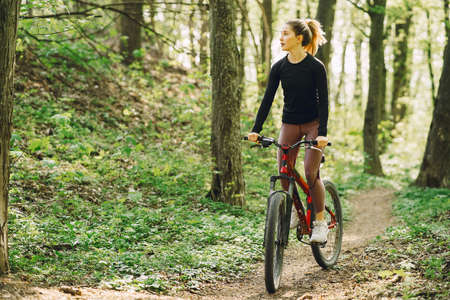 Woman riding a mountain bike in the forestの写真素材