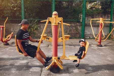 Family with little son playing on a playground