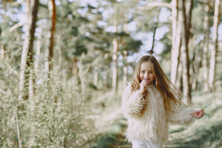 Cute little girl playing in a summer forestの写真素材