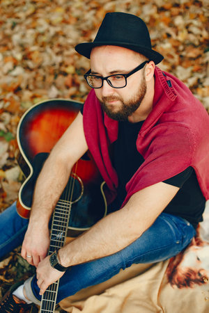 Handsome man sitting in a autumn park