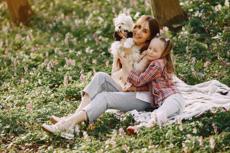Mother with daughter in a spring forest with dog
