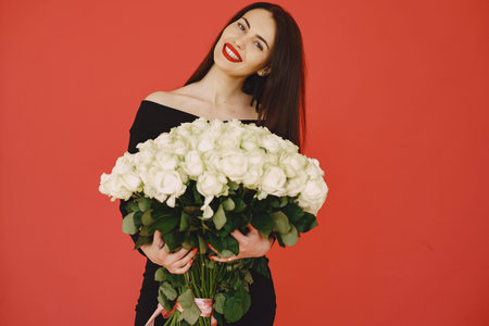 Woman in a black dress with bouquet of roses