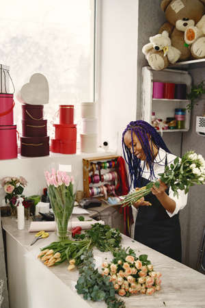 Portrait of joyful African American young woman in flower storeの写真素材