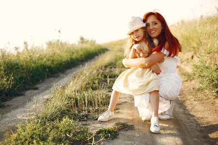 Mother with daughter playing in a summer fieldの写真素材
