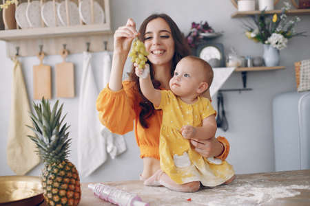 Mother playing with little daughter at homeの写真素材