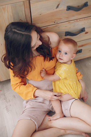 Mother playing with little daughter at home